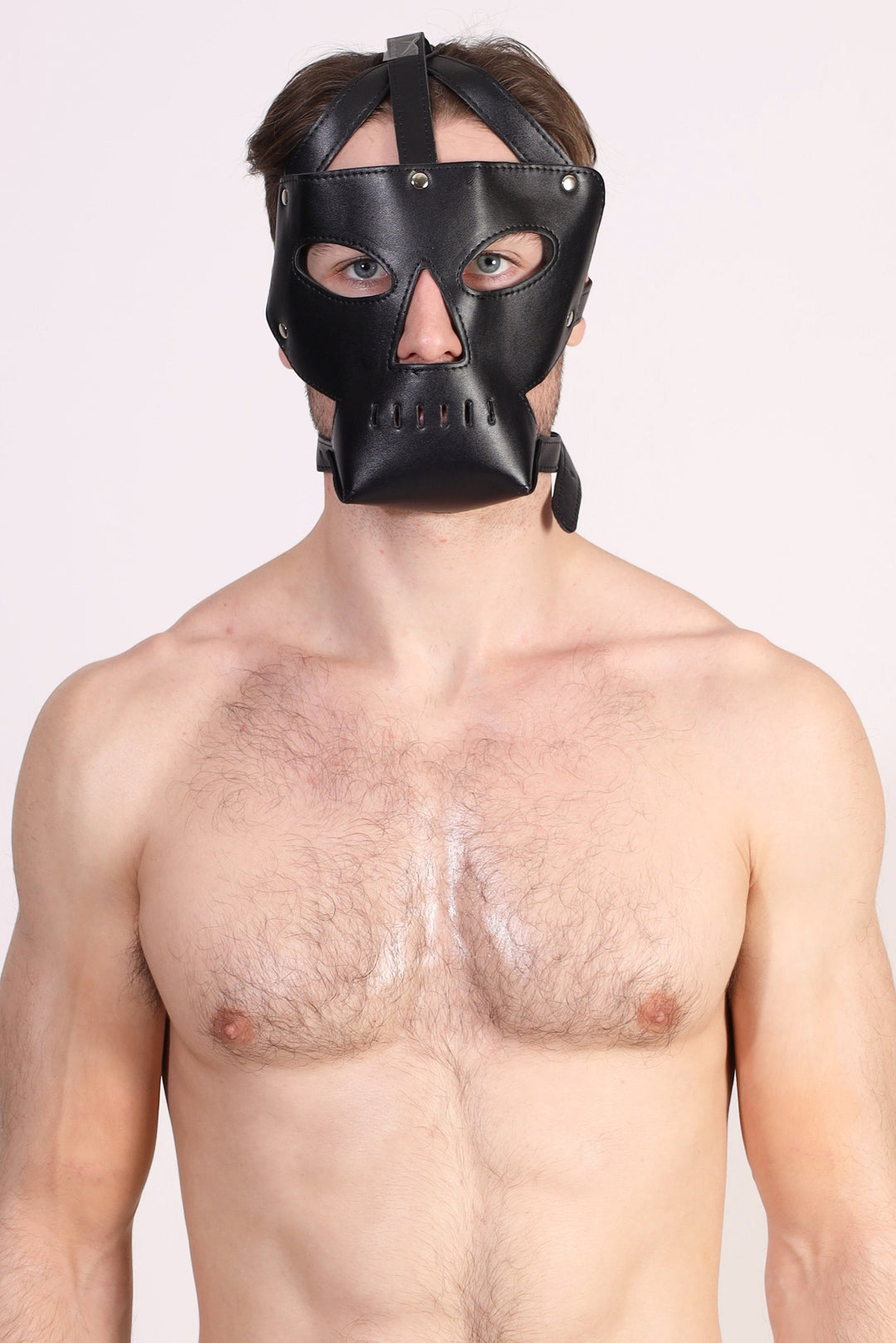 Mascarilla facial de cuero con aberturas para ojos y nariz, y rejilla bucal transpirable.